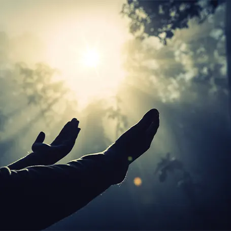 Uma imagem de uma pessoa a levantar as mãos para o céu