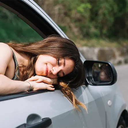 Uma imagem de uma mulher a dormir no seu carro.