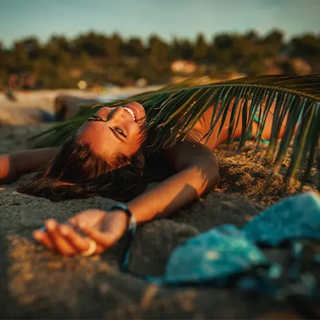 Uma jovem mulher a dormir na praia ao fim da tarde