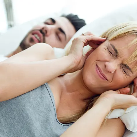 Um homem a ressonar ao lado de uma mulher que não consegue dormir