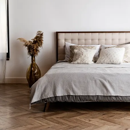 A modern bedroom with white sheets on a bed