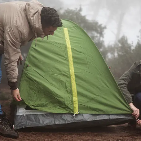 Uma imagem de um casal a montar uma tenda impermeável