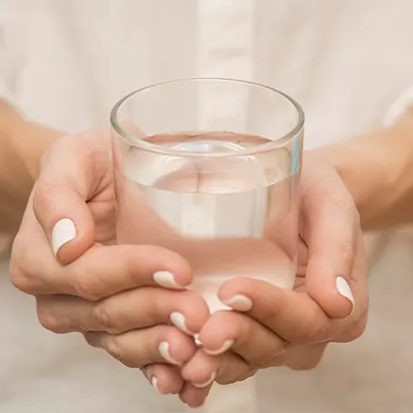 An image of a woman holding a glass of water.