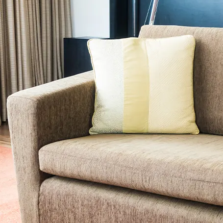 An image of a corner of a sofa bed with a pillow