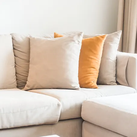 An image of a corner sofa bed with pillows on it