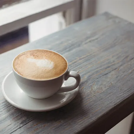 Uma imagem de uma chávena de café sobre uma mesa.