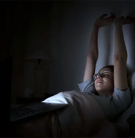 Uma imagem de uma mulher na cama com luz artificial a iluminar-lhe o rosto