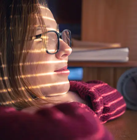 An image of a woman with light shining on her face